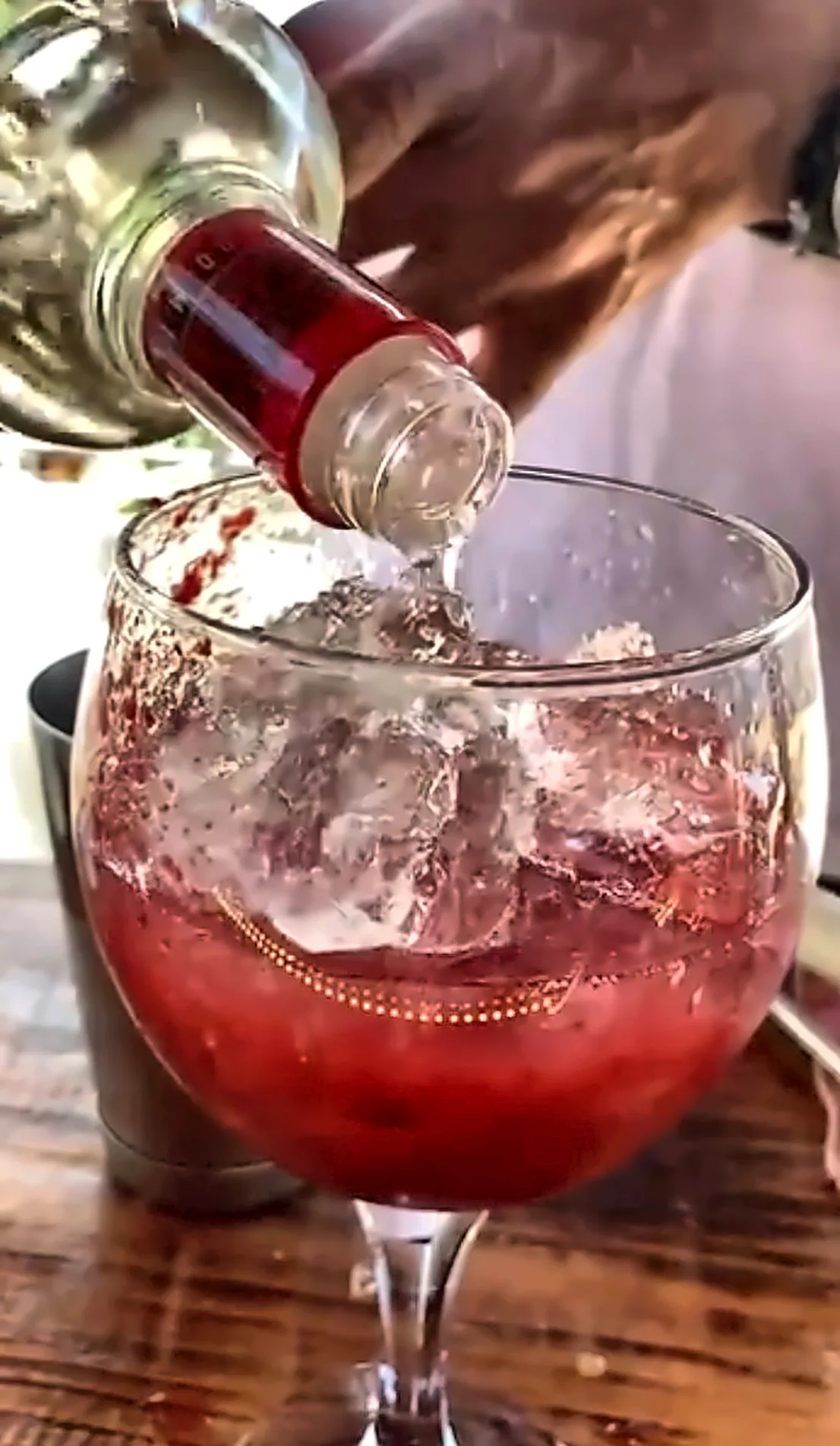 Preparo real de drink vermelho com gelo